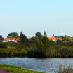 A modern windmill in the distance along a bike route in Zaanstad